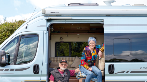 Two people relaxing  by their campervan